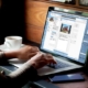 Frau überträgt Immobilien aus onOffice auf Facebook am Laptop